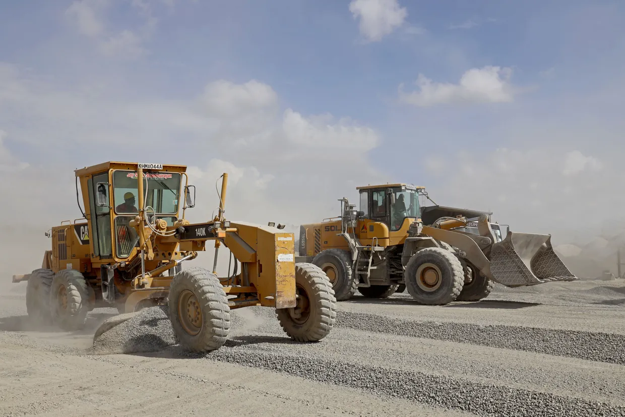 A grader and a loader working a gravel road base