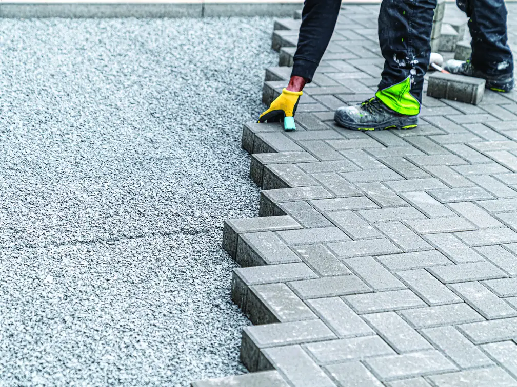 Paving blocks being laid in a herringbone pattern